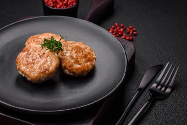 Kızarmış et köftesi, domuz eti ya da tuzlu tavuk, baharat ve ottan oluşan koyu beton bir arka planda.