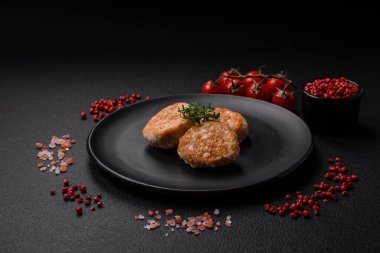 Kızarmış et köftesi, domuz eti ya da tuzlu tavuk, baharat ve ottan oluşan koyu beton bir arka planda.