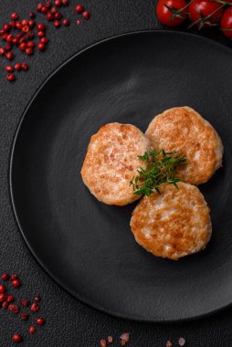 Kızarmış et köftesi, domuz eti ya da tuzlu tavuk, baharat ve ottan oluşan koyu beton bir arka planda.