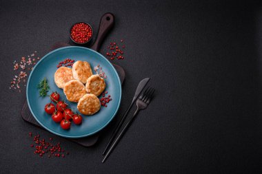 Kızarmış et köftesi, domuz eti ya da tuzlu tavuk, baharat ve ottan oluşan koyu beton bir arka planda.