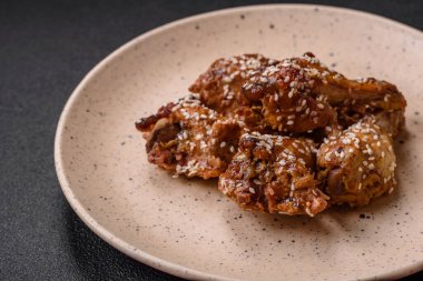 Lezzetli ızgara tavuk kanatları. Tuz, baharat ve teriyaki soslu. Koyu beton arka planda.