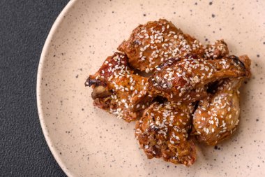 Lezzetli ızgara tavuk kanatları. Tuz, baharat ve teriyaki soslu. Koyu beton arka planda.