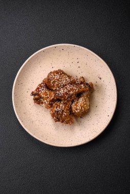 Lezzetli ızgara tavuk kanatları. Tuz, baharat ve teriyaki soslu. Koyu beton arka planda.