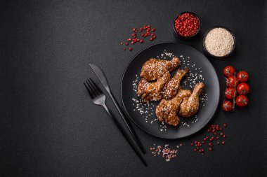 Lezzetli ızgara tavuk kanatları. Tuz, baharat ve teriyaki soslu. Koyu beton arka planda.