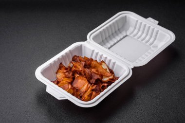 Koyu beton arka planda tuzlu ve baharatlı çıtır patates cipsi.