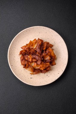 Koyu beton arka planda tuzlu ve baharatlı çıtır patates cipsi.