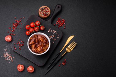 Koyu beton arka planda tuzlu ve baharatlı çıtır patates cipsi.