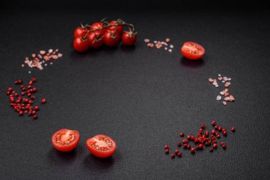 Koyu beton zeminde domates, tuz, baharat ve otlar pişirmek için gerekli malzemeler.