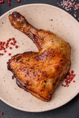 Lezzetli ızgara tavuk budu ya da koyu beton arka planda tuz ve baharatlı çeyreklik.