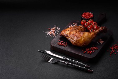 Lezzetli ızgara tavuk budu ya da koyu beton arka planda tuz ve baharatlı çeyreklik.