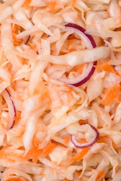 Delicious pickled salted cabbage with carrots, salt and spices in a ceramic plate