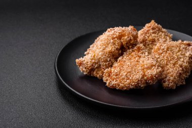 Delicious fresh crispy chicken nuggets on a dark concrete background. Unhealthy food, fast food