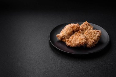 Delicious fresh crispy chicken nuggets on a dark concrete background. Unhealthy food, fast food