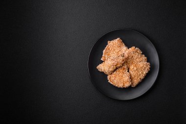 Delicious fresh crispy chicken nuggets on a dark concrete background. Unhealthy food, fast food