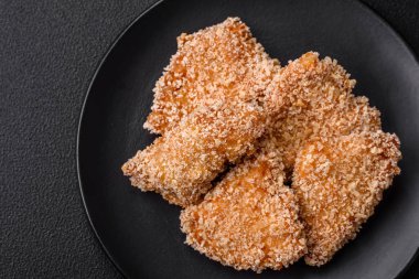 Delicious fresh crispy chicken nuggets on a dark concrete background. Unhealthy food, fast food