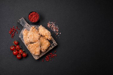 Delicious fresh crispy chicken nuggets on a dark concrete background. Unhealthy food, fast food