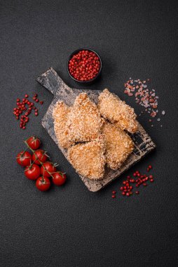 Delicious fresh crispy chicken nuggets on a dark concrete background. Unhealthy food, fast food
