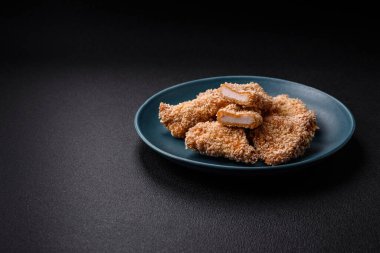 Delicious fresh crispy chicken nuggets on a dark concrete background. Unhealthy food, fast food