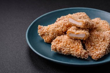 Delicious fresh crispy chicken nuggets on a dark concrete background. Unhealthy food, fast food