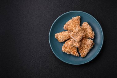 Delicious fresh crispy chicken nuggets on a dark concrete background. Unhealthy food, fast food