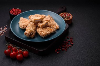 Delicious fresh crispy chicken nuggets on a dark concrete background. Unhealthy food, fast food
