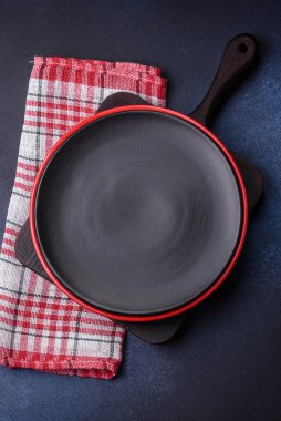 Beton desenli arka planda yuvarlak, boş seramik plaka. Akşam yemeği için tabak ve çatal bıçak hazırlıyorum.