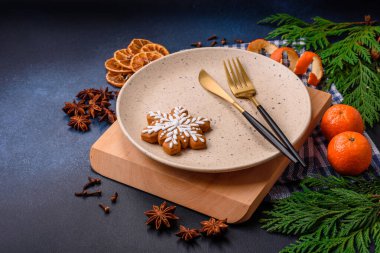 Boş bir tabağın, mandalinanın, zencefilli ekmeğin ve arka planda yıldız anasonunun güzel Noel kompozisyonu.