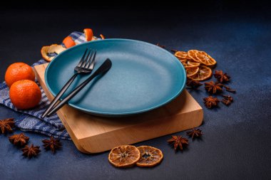 Boş bir tabağın, mandalinanın, zencefilli ekmeğin ve arka planda yıldız anasonunun güzel Noel kompozisyonu.