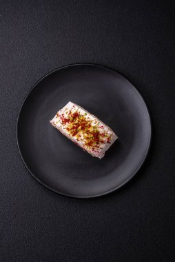 Bir parça lezzetli kremalı makarna, mascarpone peyniri, böğürtlen ve badem ve koyu beton arka planda.