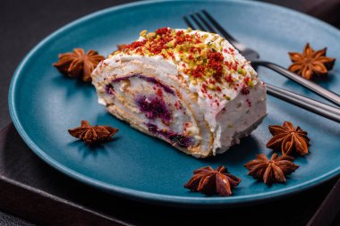 Bir parça lezzetli kremalı makarna, mascarpone peyniri, böğürtlen ve badem ve koyu beton arka planda.