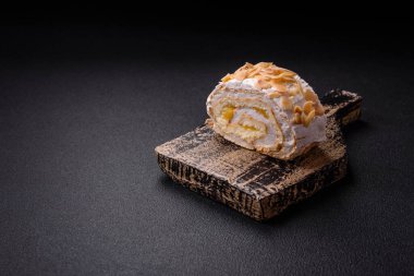 Bir parça lezzetli kremalı makarna, mascarpone peyniri, böğürtlen ve badem ve koyu beton arka planda.