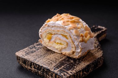 Bir parça lezzetli kremalı makarna, mascarpone peyniri, böğürtlen ve badem ve koyu beton arka planda.