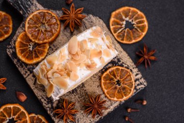 Bir parça lezzetli kremalı makarna, mascarpone peyniri, böğürtlen ve badem ve koyu beton arka planda.