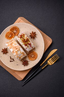 Bir parça lezzetli kremalı makarna, mascarpone peyniri, böğürtlen ve badem ve koyu beton arka planda.