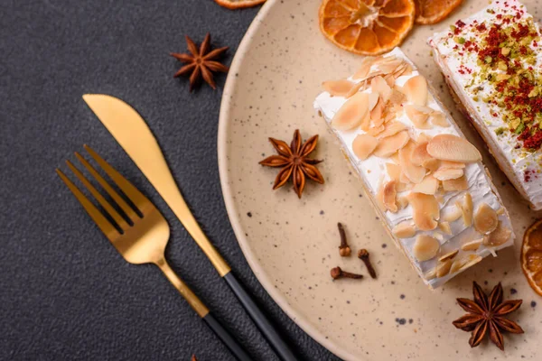 Bir parça lezzetli kremalı makarna, mascarpone peyniri, böğürtlen ve badem ve koyu beton arka planda.