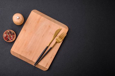 Koyu beton arka planda boş dikdörtgen ahşap kesim tahtası. Evde yemek pişirmek.