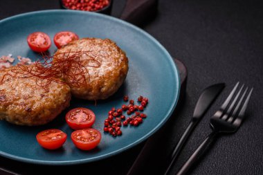 Lezzetli taze kıymalı balık pirzolası. Esmer arka planda baharatlar ve otlarla birlikte.