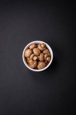 Izgarada pişirilmiş lezzetli sulu şampiyonlar koyu beton arka planda seramik tabakta tuz ve baharatlarla.