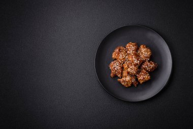 Lezzetli Asya yemeği teriyaki soslu tavuk parçaları ve koyu beton arka planda tuz ve baharatlar.