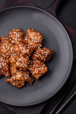 Lezzetli Asya yemeği teriyaki soslu tavuk parçaları ve koyu beton arka planda tuz ve baharatlar.