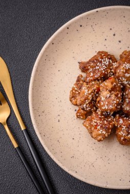 Lezzetli Asya yemeği teriyaki soslu tavuk parçaları ve koyu beton arka planda tuz ve baharatlar.