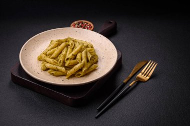 Fesleğen, tuz ve baharatlı yeşil pesto soslu lezzetli taze makarna.