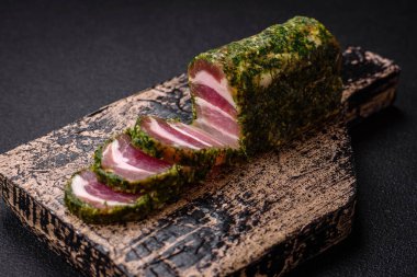 Lezzetli taze pastırma şeritleri, baharatlar ve koyu beton arka planda tuz.