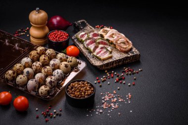 Koyu beton arka planda plastik bir kutuda çiğ bıldırcın yumurtası. Besleyici bir kahvaltı hazırlıyorum.