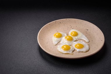 Kızarmış bıldırcın yumurtası, domuz pastırması, baklava ve tuz, baharat ve çimento kaplı kiraz domatesli lezzetli bir kahvaltı.