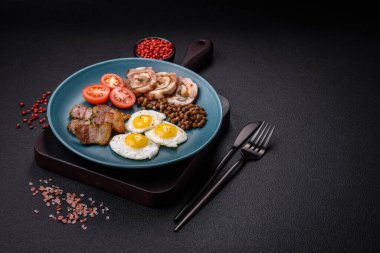 Kızarmış bıldırcın yumurtası, domuz pastırması, baklava ve tuz, baharat ve çimento kaplı kiraz domatesli lezzetli bir kahvaltı.