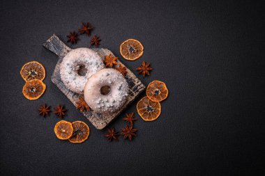Gümüş boncuklu ve koyu beton arka planda kremalı lezzetli, taze, beyaz ya da bej bir çörek.
