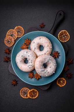 Gümüş boncuklu ve koyu beton arka planda kremalı lezzetli, taze, beyaz ya da bej bir çörek.