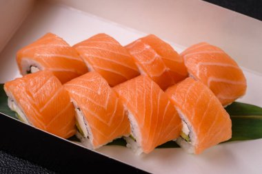 Somon, karides, salatalık ve krem peynirli lezzetli Philadelphia suşi rulosu.