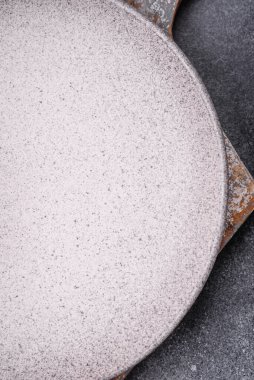 Boş yuvarlak seramik tabağı desenli beton arka planda mutfak gereçleri olarak kullan